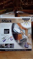 Photo of Shark Portable Steam Pocket System box showing product use and features