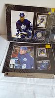 Wide view of both framed memorabilia lots showing images of hockey players in blue Toronto Maple Leafs jerseys, trading cards, and collectible coins.