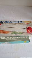 Photo of the Double Seal vacuum bag sealer box with image of vegetables and brand name.