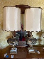 Pair of lamps on wooden dresser with mirror, showing full view and matching fabric shades