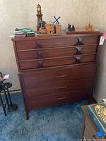 Front view of walnut veneer dresser with seven drawers and brushed metal handles