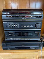 Front view of Panasonic compact audio system showing the receiver/tuner, equalizer, cassette decks, and Symphonic CD player stacked.