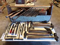Photo showing full contents of wooden tool carrier and tools laid out on table