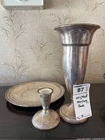 Full view of the weighted sterling silver vase, candlestick, and platter, showing tarnishing and general condition.