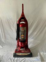 Front view of red Bissell Lift-Off upright vacuum with transparent dust container and cord wrapped on side
