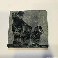 Full view of the 7x7 inch sculpted marble panel depicting three Inuit figures.