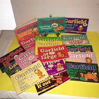 Front view of all 15 vintage Garfield comic books showing colorful covers and titles.