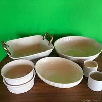 Photo showing all items: rectangular handled serving dish, large round bowl, oval fluted bowl, two ramekins, two ribbed side bowls.