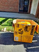 Original DeWalt box showing wear and tear on yellow cardboard with product images and specs for vacuum model DC500.