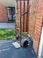 Front view of the metal two-wheel hand truck dolly showing the frame, handles, and base plate.