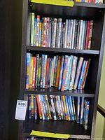 Three shelves filled with a variety of DVD cases showing titles and artwork of movies and TV series.