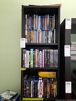 3 shelves filled with DVDs and Blu-rays showing a variety of movie and TV titles.
