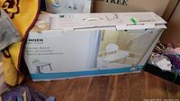 Original box of Moen Home Care Transfer Bench showing product name and image of the bench in bathroom setting.