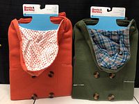 Two Boots & Barkley dog pea coats in red and green, neatly folded, showing buttons and lining patterns.