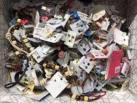 Pile of assorted costume earrings and some bracelets, mostly on white display cards with various colored beads and metal pieces.