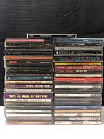 Stacks of 44 music CDs showing album spines and covers to identify artists and genres including rock, soft rock, country, and R&B