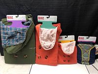 Four Boots & Barkley pet coats displayed upright, showing napped buttons, hoods, and varied colors and linings