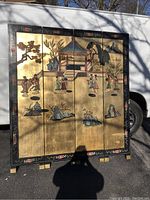 Full view of the four-panel wooden room divider with Chinese style paintings and a black floral trim.