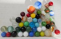 Image showing a collection of 42 assorted vintage glass marbles of various colors and patterns including one larger shooter marble.