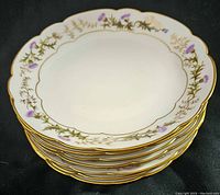 Stack of six vintage Haviland & Co Limoges decorative plates showing floral pattern on rim and scalloped edges