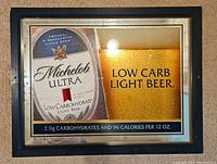 Front view of Michelob Ultra beer advertisement mirror with black frame showing text about low carbs and calories.