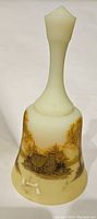 Full view of vintage Fenton glass bell with hand painted landscape featuring a cabin and trees in earth tones. Matte finish.