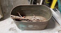 Oval vintage copper tub showing interior with some sticks and aged patina.