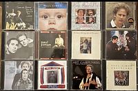 Photo showing 12 Paul Simon and Art Garfunkel CDs arranged in a grid with visible cover art for each album.