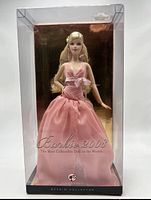 Front view of Barbie doll in box showing pink dress and packaging details.