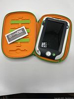 Open carrying case displaying the LeapPad Ultra tablet and instruction manual alongside slots for accessories.