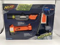 Front view of the Nerf N-Strike Modulus Long Range Upgrade Kit box showing scope, barrel extension, and stock inside packaging.