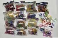 Multiple sealed and loose packs of colorful Silly Bandz rubber bands in various shapes laid out flat.