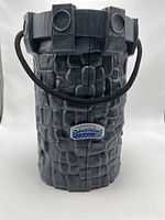 Exterior front view of the closed Skylanders carrying case showing the textured stone-like design and rope handle with logo.