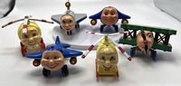 Front view of the six Jay Jay The Jet Plane toys including multiple smiling propeller planes and one wooden biplane figure