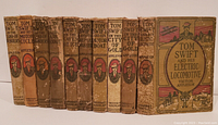 Row of 11 Tom Swift hardcover children's books with visible wear, titles legible on spines.