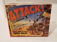 Front view of Attack! tabletop war strategy game box showing illustrated war scene with soldier, planes, and tanks, and large title text.
