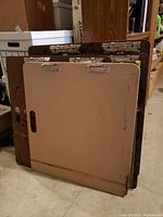 Four large clipboards stacked together showing various paint stains and wear on surfaces