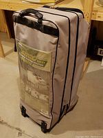 Front view of Northwest Territory folding air mattress in original stow and carry case with handle and wheels.