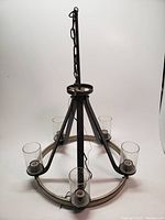 Full view of the chandelier light showing the circular metal frame, five bubbled glass shades, and hanging chain.