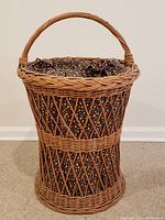 Front view of the standing wicker laundry basket showing the basket body, woven pattern, and fabric lining with colorful floral print.