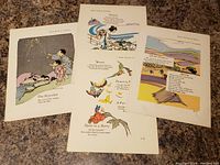 Four vintage Japanese art prints arranged side by side on fabric surface, showing colorful illustrations with poetry text.