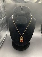 Necklace displayed on black velvet bust showing chain and pendant