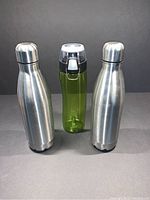 Three water bottles: two stainless steel and one green BPA free plastic with black flip-top lid.