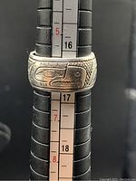 Front view showing detailed eagle head design and band width on ring sizer tool indicating size 6