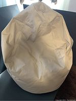 Beige bean bag chair seen from front showing the shape and stitching.