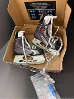 Pair of Bauer Vapor X-60 junior ice hockey skates in size US 4.5 inside a box, showing overall new condition and packaging.