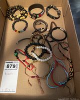 Box with 16 assorted bracelets showing leather, fabric, and beaded styles with different closures.