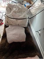 Queen size white comforter in Westin Hotels branded clear storage bag, knit throw blanket and faux fur blanket laid out visible