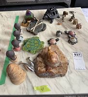 Overall assortment of animal figurines, pyramid, and coasters laid out on a table.