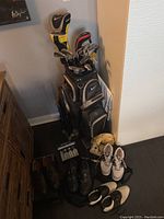Full set of clubs in bag with shoes and accessories arranged on floor